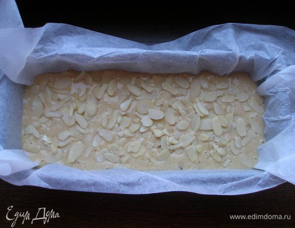 Смешать влажные и сухие ингредиенты и вылить в форму, застеленную пергаментом. Сверху посыпать миндальными хлопьями.