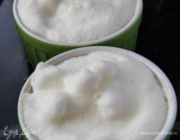 Белки взбить с помощью миксера или блендера до крепких пиков, аккуратно добавить сливки, так, чтобы белки не опали, и еще раз немного взбить. В каждую кокотницу распределить белки, немного размешать с начинкой.