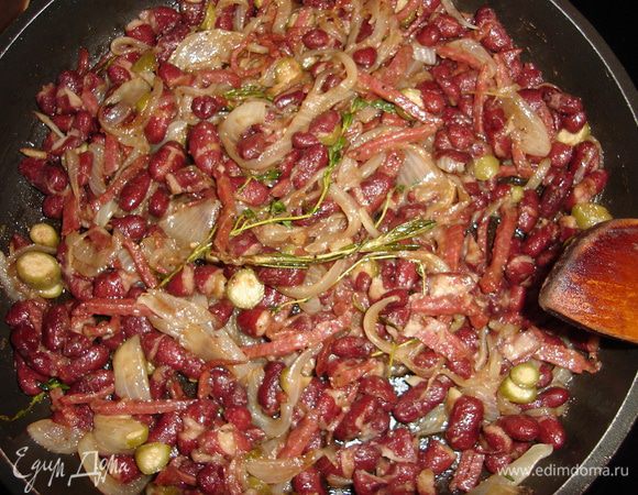 В классической последовательности спассеруем лук перьями и измельченный чеснок в смеси сливочного и оливкового масла. Добавим черный перец и веточки трав. С фасоли сливаем жидкость и добавляем к луку. Еще томим, приправляем бальзамическим уксусом, теперь колбаску соломкой и каперсы. Огонь можно отключать и дать начинке дойти. Солить не нужно, соль отдадут колбаска и сыр.