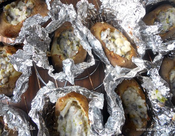 Картофель наполнить получившейся начинкой, сбрызнуть оливковым маслом.Снова завернуть фольгой (можно не плотно) и поместить в духовку минут на 20. После чего раскрыть фольгу, присыпать картофель тертым сыром, при необходимости еще раз сбрызнуть маслом (по кусочку сливочного будет совсем уместно, но не агитирую) и вернуть в духовку еще на 10 минут, или пока сыр на расплавится.