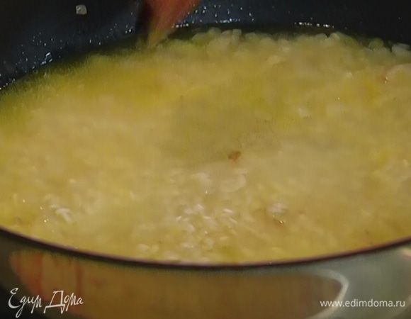 Всыпать рис и влить два половника бульона. Первые минуты лучше не перемешивать, тогда рис получится более крахмалистым. Постепенно, по мере выкипания, половник за половником добавлять бульон.