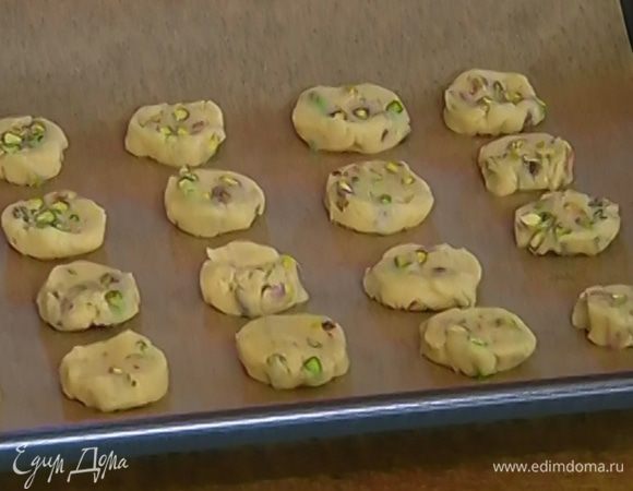 Противень выстелить бумагой для выпечки, выложить печенье, присыпать оставшимися фисташками, слегка прижав их, и отправить в разогретую духовку на 7–10 минут.