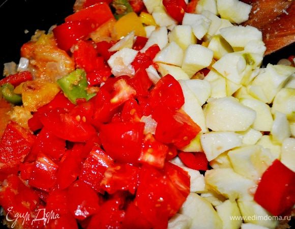 Предварительно помойте помидоры и яблоки, нарежьте дольками, добавьте к овощам и обжаривайте все вместе еще 5 минут.