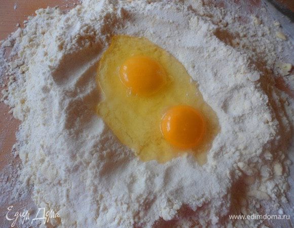 Сделать в муке с маслом углубление и разбить яйца (все ингредиенты должны быть холодными). 