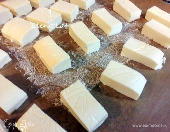 Затем застывшую массу выложить из формы, просто перевернув ее, снять пленку. Разрезать заготовку на конфеты.