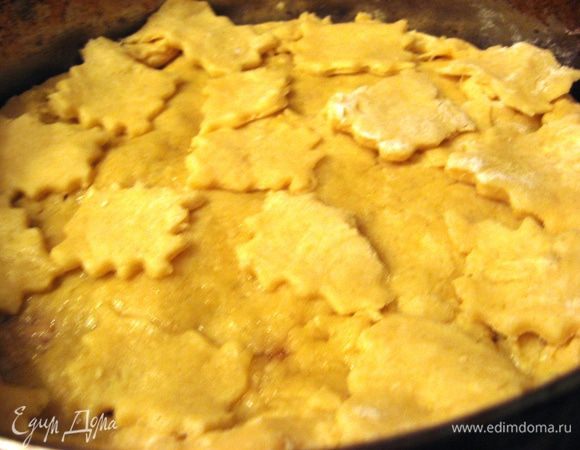 Раскатываем вторую половину теста. Накрываем начинку. Лишнее обрезаем.Украшаем по желанию оставшимся тестом. Желток взбиваем вместе со сливками и смазываем верх пирога. 