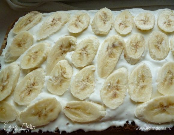 И начинаем собирать торт:корж выкладываем на блюдо, распределяем по нему 4-5 столовые ложки пропитки,затем наносим крем и выкладываем слой бананов,нарезанных ломтиками.