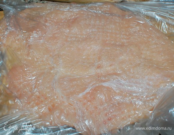 Грудки поместите в пакет или оберните пищевой пленкой, отбейте с двух сторон на кухонной доске.