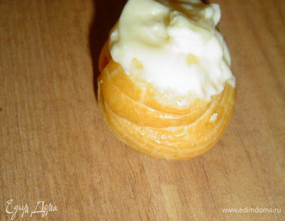 У профитролей срезаем верхушки и заполняем их кремом.