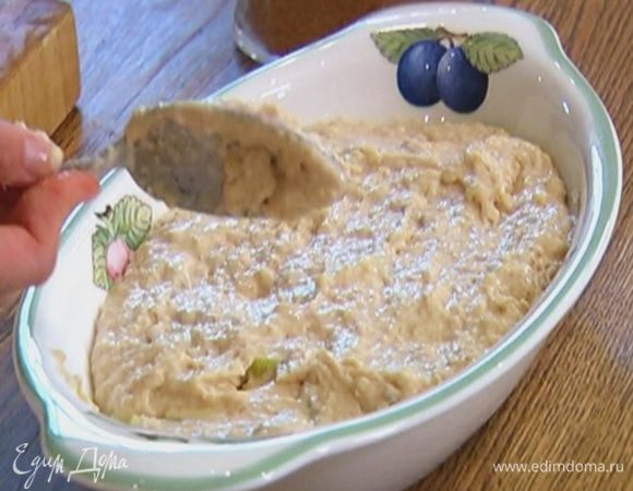 На дно керамической формы выложить половину яблок, слегка посыпать сахаром, а сверху выложить тесто.