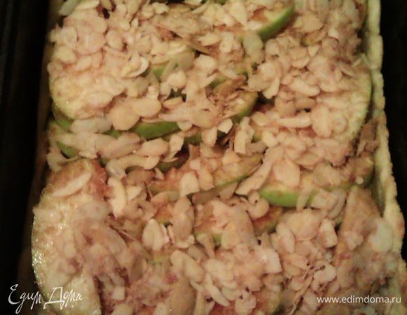 Выкладываем сверху яблоки, посыпаем оставшейся в миске смесью из миндаля и коричного сахара.