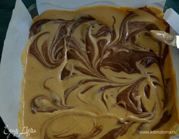 Выльем остальную тыквенную массу в форму с готовой основой.Распределим аккуратно лопаточкой.
Затем выложим сверху ложкой или черпачком для мороженого шоколадную массу с тыквенной. Ножом аккуратно разрисуем узоры.И поставим в духовку на 50 мин. Проверяем осторожно .