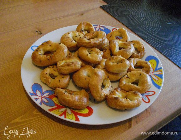 Достать шумовкой и выложить на противень (либо застеленный пекарской бумагой, либо смазанный маслом), выпекать в разогретой духовке (время индивидуально для каждой печки, у кого-то быстрее печет, у кого-то помедленнее). Можно еще перед духовкой слегка украсить кунжутом или маком, а можно и вовсе крупной солью. Я припорошила тмином.
После духовки выложить на блюдо и дать полностью остыть, иначе будут мягкие внутри, как булочки, но с крепкой коркой :)


Приятного чаепития! :)