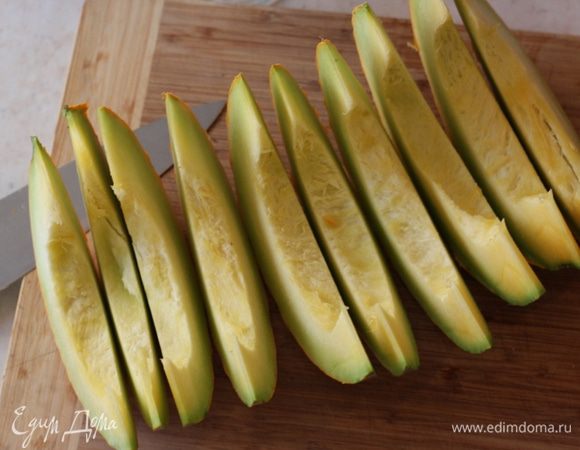 Нарежьте тыкву на дольки, как будто режете дыню или арбуз. Дольки должны быть не толще пары сантиметров.
Если дольки сильно закругленные (как у меня в этот раз), можете разрезать дольки на несколько частей.