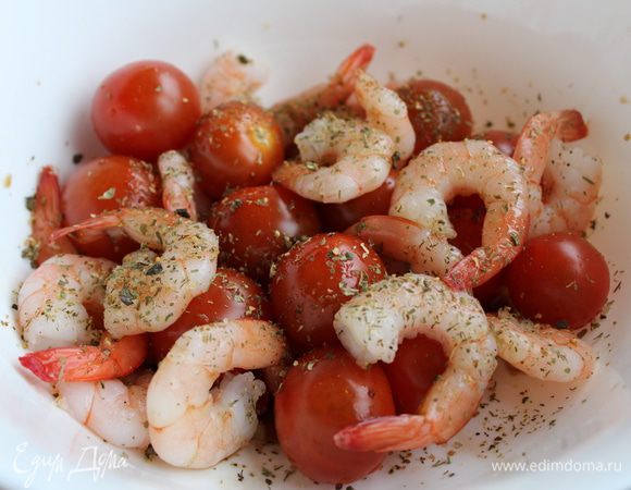 Хвостики креветок, не размораживая, положить в чашку вместе с помидорами, посыпать сухими травами, полить оливковым маслом и оставить на 30 минут.