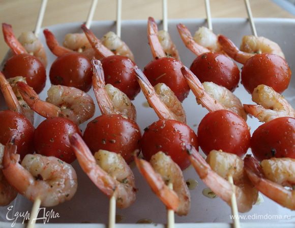 Деревянные шпажки предварительно замочить в холодной воде на 10-15 минут. Нанизать креветки и помидоры. Запекать в духовке 20 минут. Подавать горячими.
