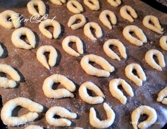 Из теста скатать жгутики и сложить их в овальные крендельки, обваляв их в сахаре.
Выложить печенье на противень, застеленный пергаментом и выпекать при 180С примерно 15 минут, до золотистого цвета. 