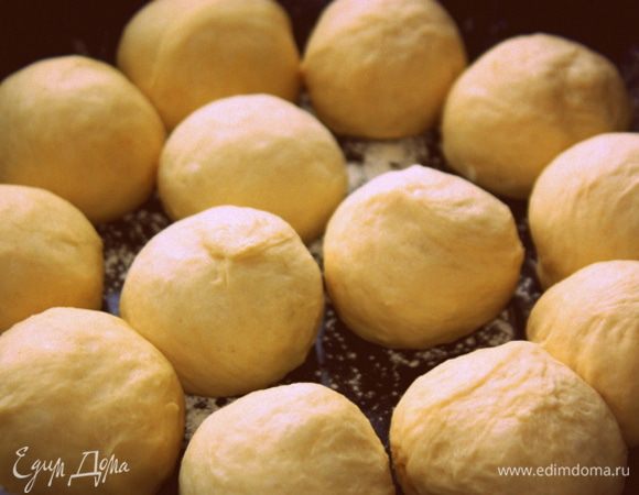 Когда тесто увеличится вдвое, смажьте руки растительным маслом и сформируйте из теста шарики, уложите в противень, который тоже смазан маслом. Оставьте тесто, оно должно немного подняться.<br />
Выпекайте 30–40 минут при 180°C, время и температура зависят от вашей духовки. 