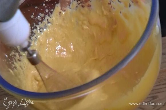 В другой посуде соединить оставшийся сахар с желтками, влить ванильный экстракт и миксером взбить в светлую, пышную массу.