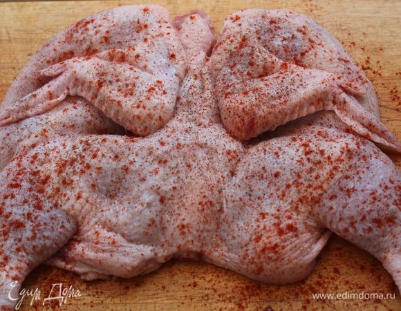 Натереть цыпленка внутри и снаружи солью, перцем и выдавленным чесноком. Посыпать паприкой.