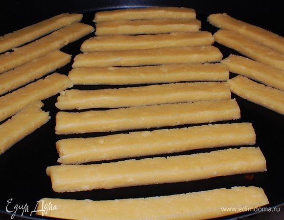 Нарезать на палочки шириной 1-1,5 см, произвольной длины, и выложить в форму с тефлоновым покрытием.