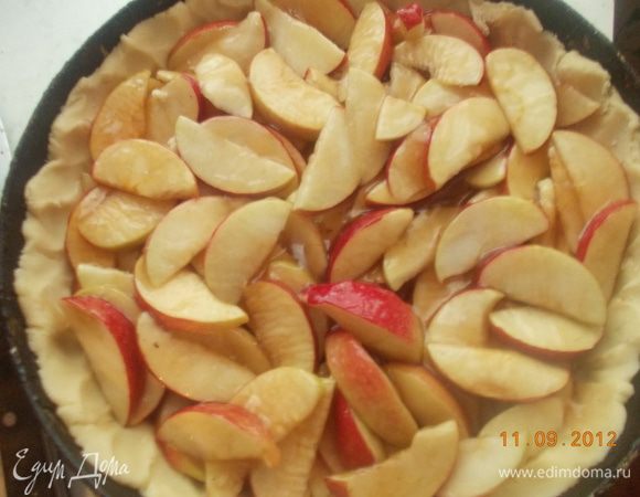 Тесто раскатать и уложить в форму с бортами. Выложить туда яблоки и вылить сироп. 