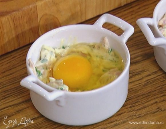 Разложить сырную массу в 4 кокотницы, сделать в середине небольшие углубления и разбить в каждое по одному яйцу, посолить и поперчить.