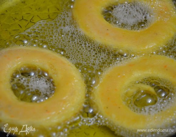 На посыпанной мукой рабочей поверхности раскатать тесто.толщиной около 1 - 1,5 см. Вырезать пончики. Нагреть растительное масло с сковороде на среднем огне. Обжарить пончики в масле, в одной стороны, перевернуть и обжарить со второй стороны. Примерно около 3 - 4 минут. Пончики не должны соприкасаться.