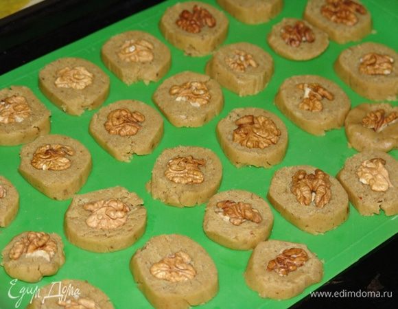 Нарезаем колбаски теста на кусочки толщиной 0.5 см, хорошо вдавливаем по половинке ореха. Выпекаем в разогретой до 180 градусов духовке около 15-20 минут. 
