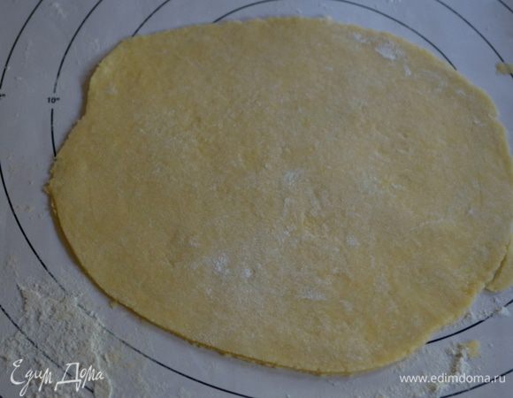 Выложим тесто на припыленную мукой поверхность и помнем его еще 3-5 мин. Разделим тесто на 2 части, одна часть должна быть чуть больше второй.Тесто раскатаем под нашу круглую форму.Большая часть теста идет под основу, меньшая на поверхность пирога.