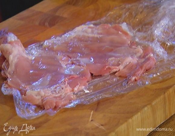 Куриное филе обернуть двойным слоем пищевой пленки и отбить скалкой.