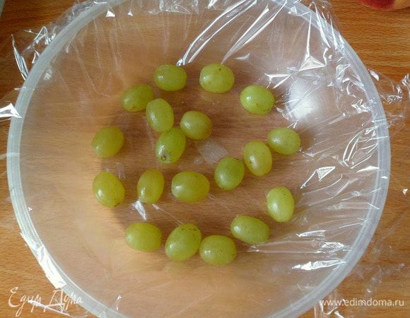 Затем берем формочку, в которую будем заливать мусс-желе. Застилаем пищевой пленкой и на дно укладываем виноградины