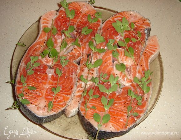 Разделайте рыбу: очистите, промойте брюшко, нарежьте необходимое количество порционных стейков. Кожу и косточки я не удаляю, так рыба будет сочнее и интереснее. Теперь приправьте рыбу крупной солью, свежемолотым черным (можно взять белый или смесь) перцем, щедро посыпьте майораном, можно взять и другие травы, но мне не нужен посторонний вкус, а лишь нежный аромат. Дайте рыбе постоять около 30–60 минут.