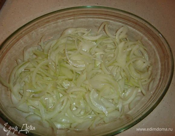 Форму для запекания лучше взять стеклянную или керамическую, чтобы прогрев был равномернее. Нарежьте две луковицы перьями и прямо в форме смешайте с щепоткой соли, перцем и двумя столовыми ложками оливкового масла, разровняйте луковую подушку для рыбы.