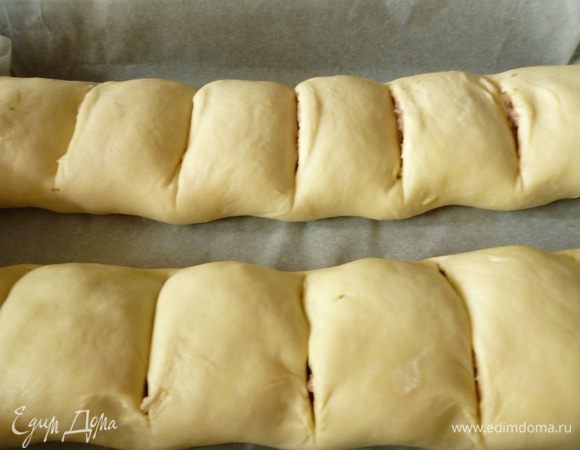 Переносим рулет на противень выстланный бумагой для выпечки,смазанной растительным маслом (я пользуюсь антипригарной бумагой и маслом ее не смазываю).Так же поступаем и с остальным тестом.Теперь делим рулет сразу на порционные куски,шириной 4-5 см. Делаем надрезы на рулете немного не до конца.Когда рулеты испекутся,то кусочки будут легко отделяться друг от друга без помощи ножа. Смазываем рулеты взбитым яйцом и выпекаем в духовке при температуре 170-180 градусов до румяной золотистой корочки.Готовые рулеты достаем из духовки,с помощью кисточки верх рулетов слегка смачиваем бульоном,накрыть полотенцем и дать постоять 10 минут. Все,можно пробовать! Приятного вам аппетита!