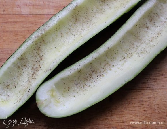 Наколоть половинки цукини вилкой, посыпать солью и перцем.