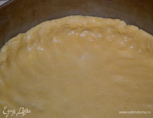 разъемную форму 24 см смазать маслом и выложить туда тесто, руками его распределить по форме, сделав бортики 2 см