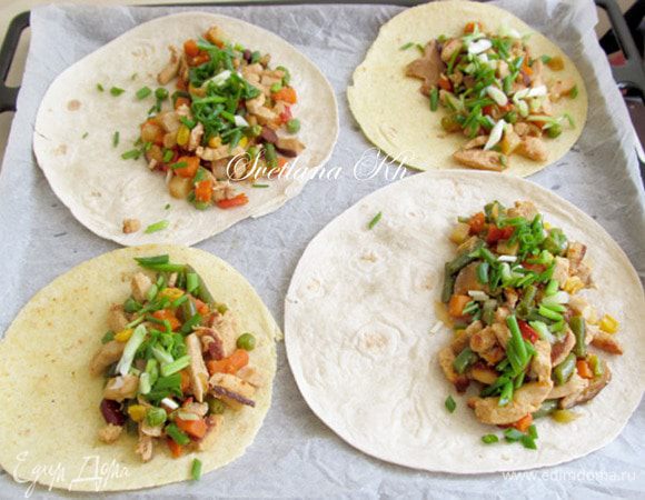 Противень выстелить пергаментом. Готовую смесь выложить на лепешки.