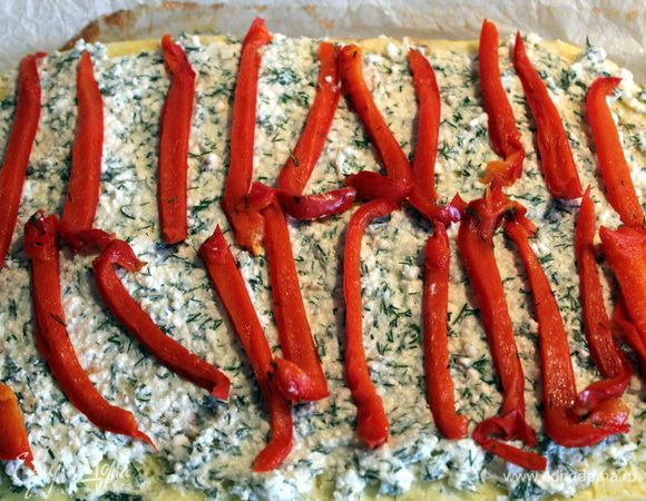 Перец предварительно запечь. Очистить от кожицы и нарезать тонкими полосками. Выложить перец на творожную начинку.