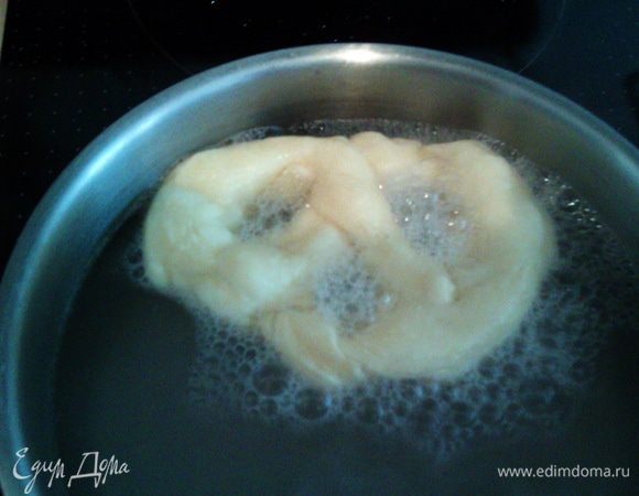 Готовим лаугу. Доводим воду до кипения, добавляем соду. Перекладываем каждый брецель с противня на шумовку (после холодильника это несложно), погружаем каждый брецель на 30 секунд в лаугу, слегка придавливая шумовкой, вылавливаем и опять отправляем на противень. С булочками проделываем то же самое.