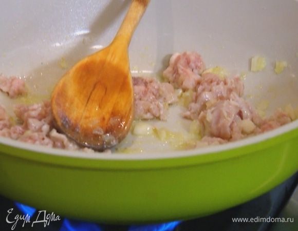Выложить фарш и чеснок в сковороду с луком, прибавить огонь и обжарить все до золотистого цвета.