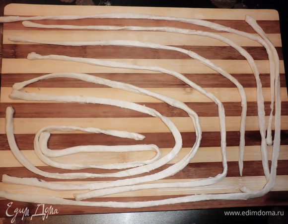Слоеное тесто нарезать полосками 1 см, немного растянуть и скрутить веревочкой.


