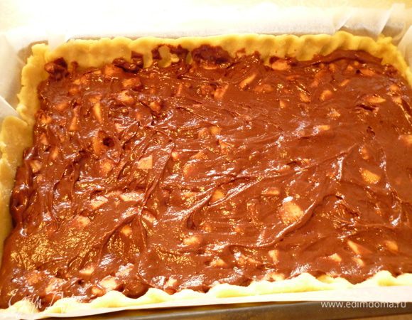 Берем кусок бумаги для выпечки,отмеряем по величине формы (включая высоту бортика), смазываем маргарином и раскатываем с помощью скалки тесто из холодильника. Вместе с бумагой переносим пласт теста в форму для выпечки,оформляем бортик. Затем равномерно распределяем шоколадно-яблочную массу. Выпекаем пирог при 170 градусах 35-40 минут. Проверяем готовность по шоколадному слою, до сухой спички. Достаем пирог из духовки, накрываем полотенцем и даем остыть. Приятного вам чаепития!