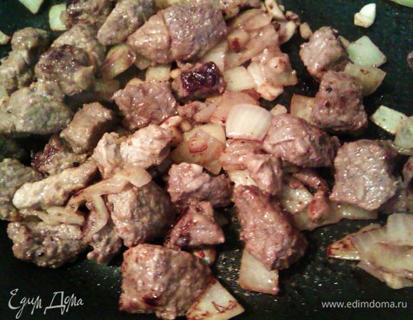 Перекладываем мясо с луком и чесноком из маринада на разогретую сковородку, отжимая маринад. Сначала на сковороде появится сок, когда он выкипит, подливаем немного подсолнечного масла. Обжариваем 10 мин. на сильном огне. Разогреваем духовку до 200 гр.