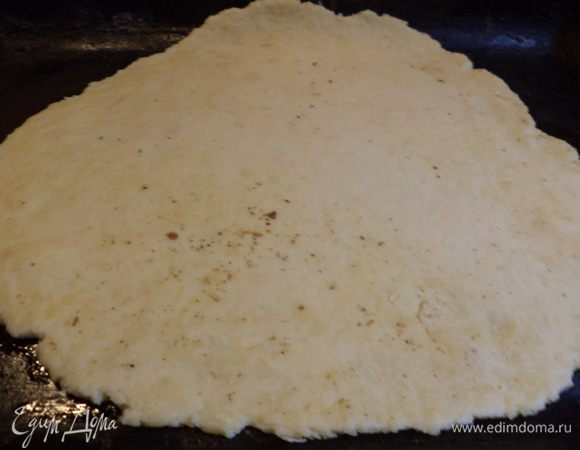 Тесто разделить на 2 неравные части, большую раскатать и положить на смазанный слегка маслом противень, у меня скалка была после разминания грецких орехов, поэтому на слое теста остались ореховые следы!