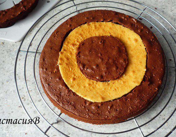 Перемешаем сметану с сахарной пудрой. Собирам пирог, заменив темное среднее кольцо светлым. 