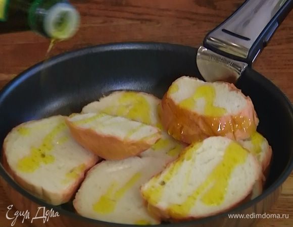 Хлеб нарезать, натереть зубчиком чеснока, выложить в форму для выпечки и слегка сбрызнуть оливковым маслом.