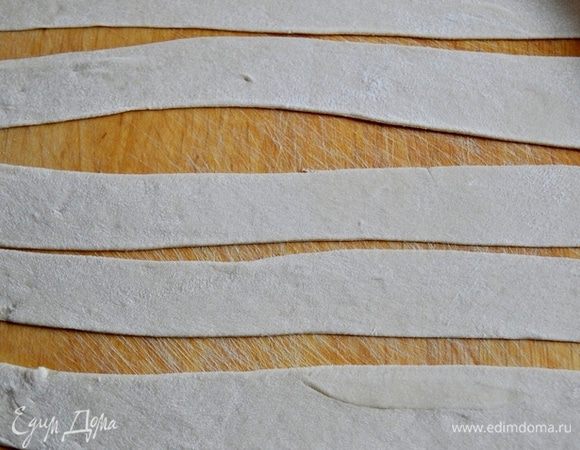 Рабочую поверхность присыпать мукой и тонко раскатать тесто,
Нарезать тесто на полоски-ленточки шириной 3 см.