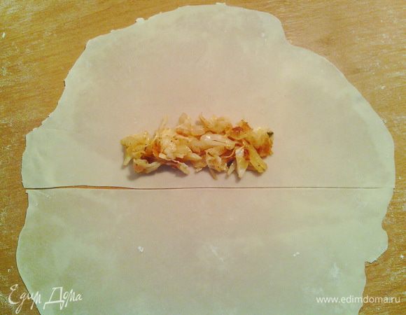 Приступим к сигарам. Раскатываем из одного шарика круг диаметром около 20 см. Разрезаем его на две части. Кладём начинку с ровной стороны