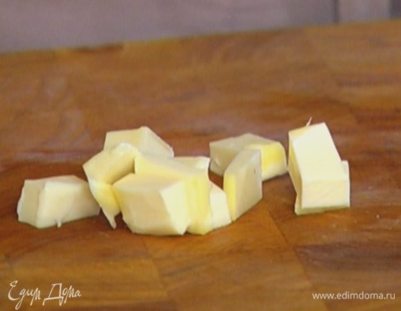 Предварительно охлажденное сливочное масло нарезать небольшими кусочками.